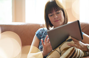 Woman on sofa looking at iPad