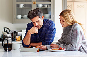 Couple sitting at table looking at iPad