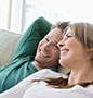 Couple sitting on sofa smiling